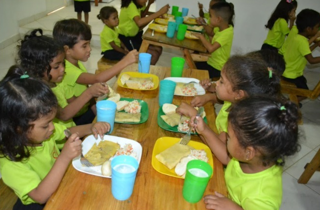 Kinderen van Casa Blanca aan tafel met hun maaltijd